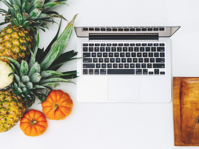 Fragebogen-zum-Projekt-Impuls-Trier Laptop auf einem Tisch, daneben Ananas und kleine Kürbisse